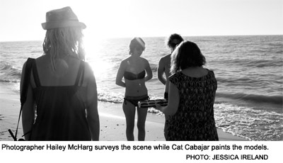 Photographer Hailey McHarg surveys the scene while Cat Cabajar paints the models.