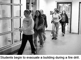 Students begin to evacuate a building during a fire drill.